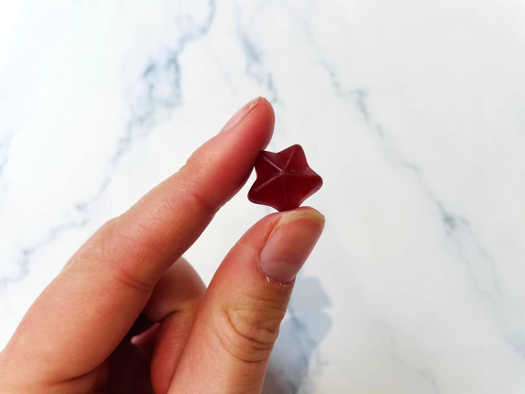 Jern og C-vitamin vingummier til børn imellem to fingre