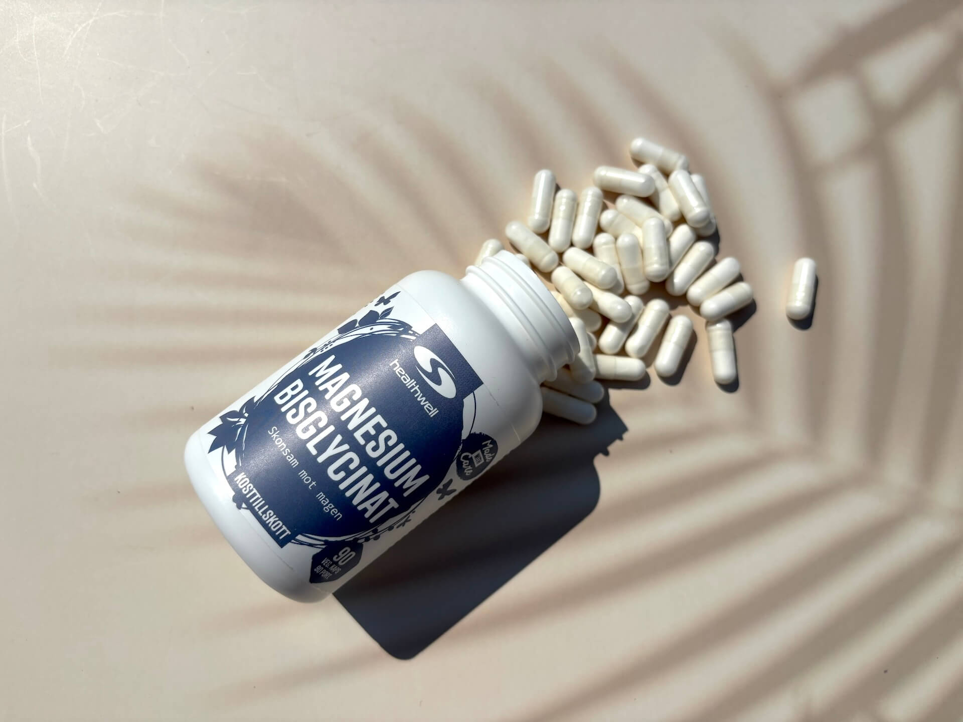 Kapsler fra Healthwell Magnesium Bisglycinat hældt ud på bord