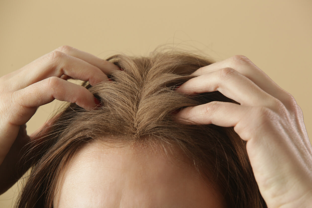 Kvinde bruger tørshampoo i håret før hair mist hårparfume