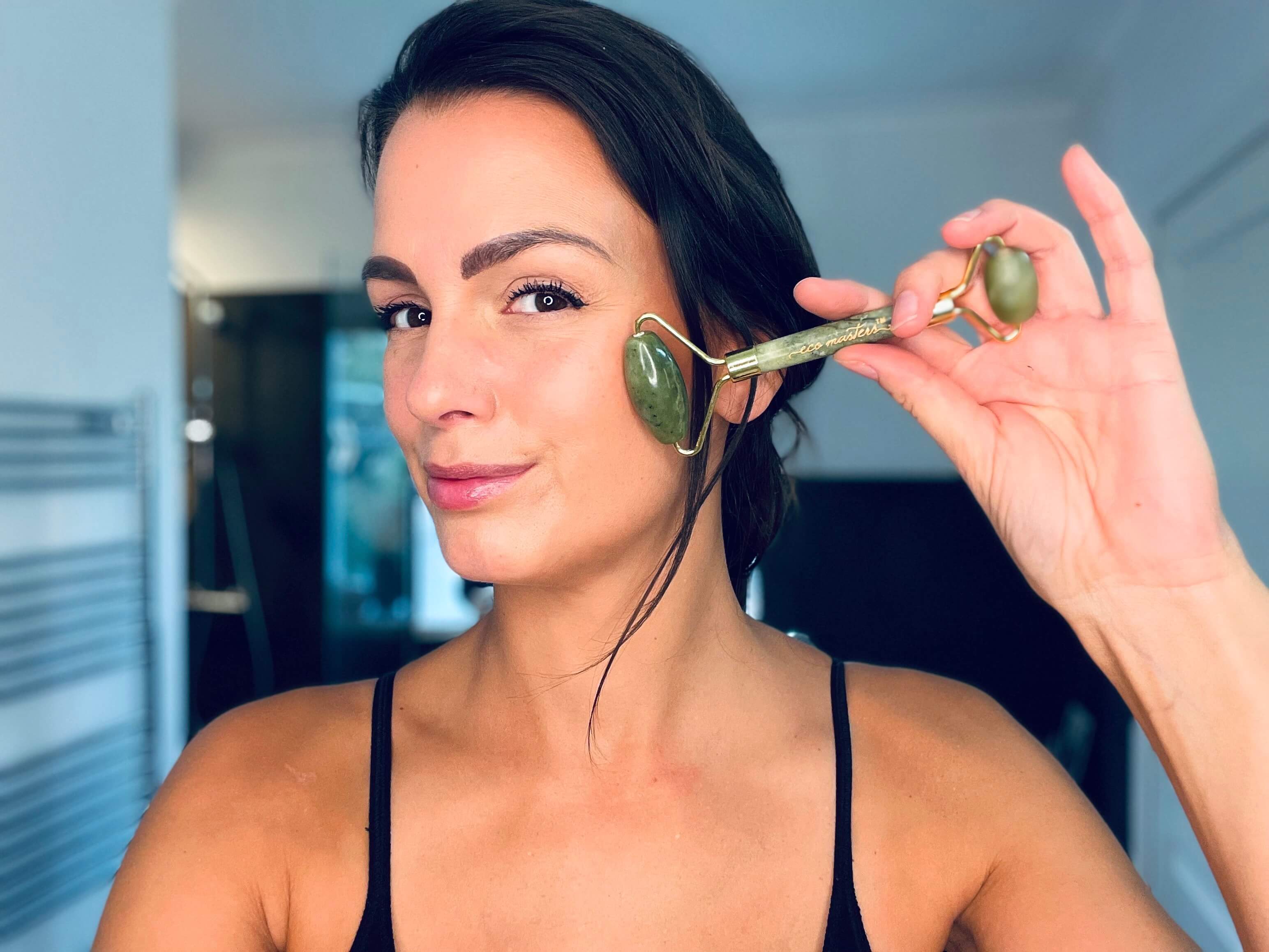 Kvinde der bruger en grøn face roller