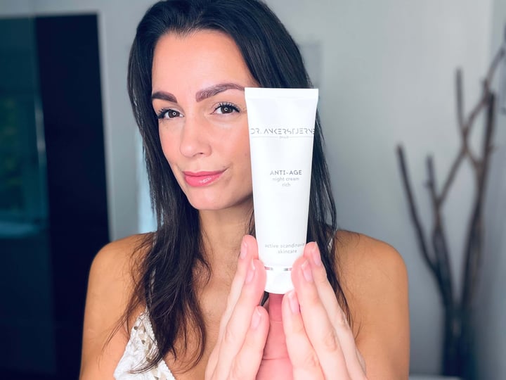Kvinde der holder ANTI-AGE nightcream rich på badeværelse