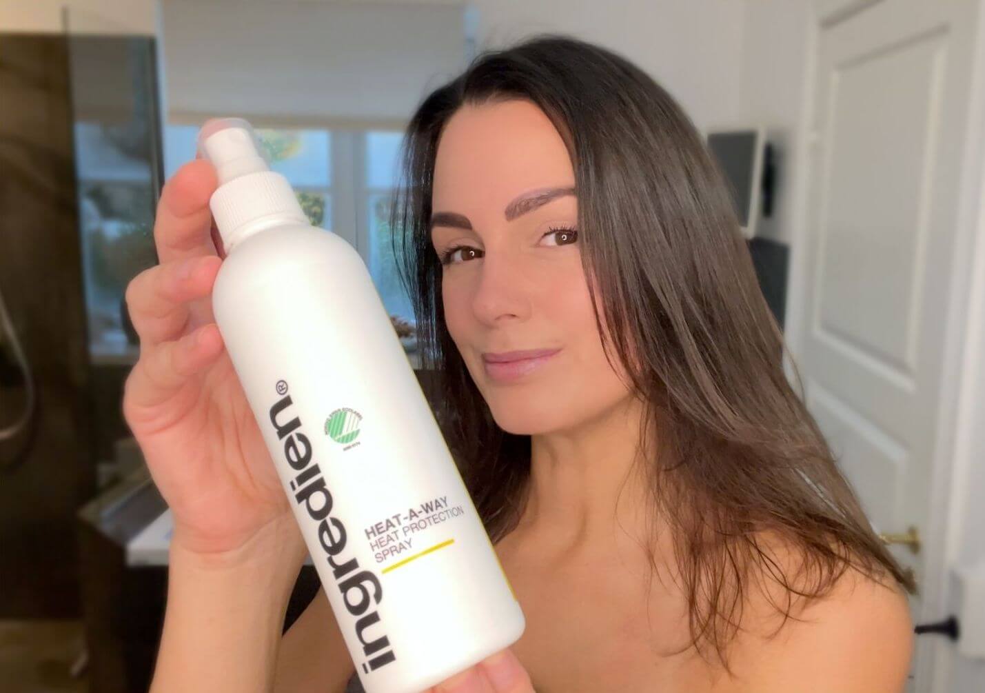 Kvinde der holder ingredien Heat-A-Way varmebeskyttende spray foran sig