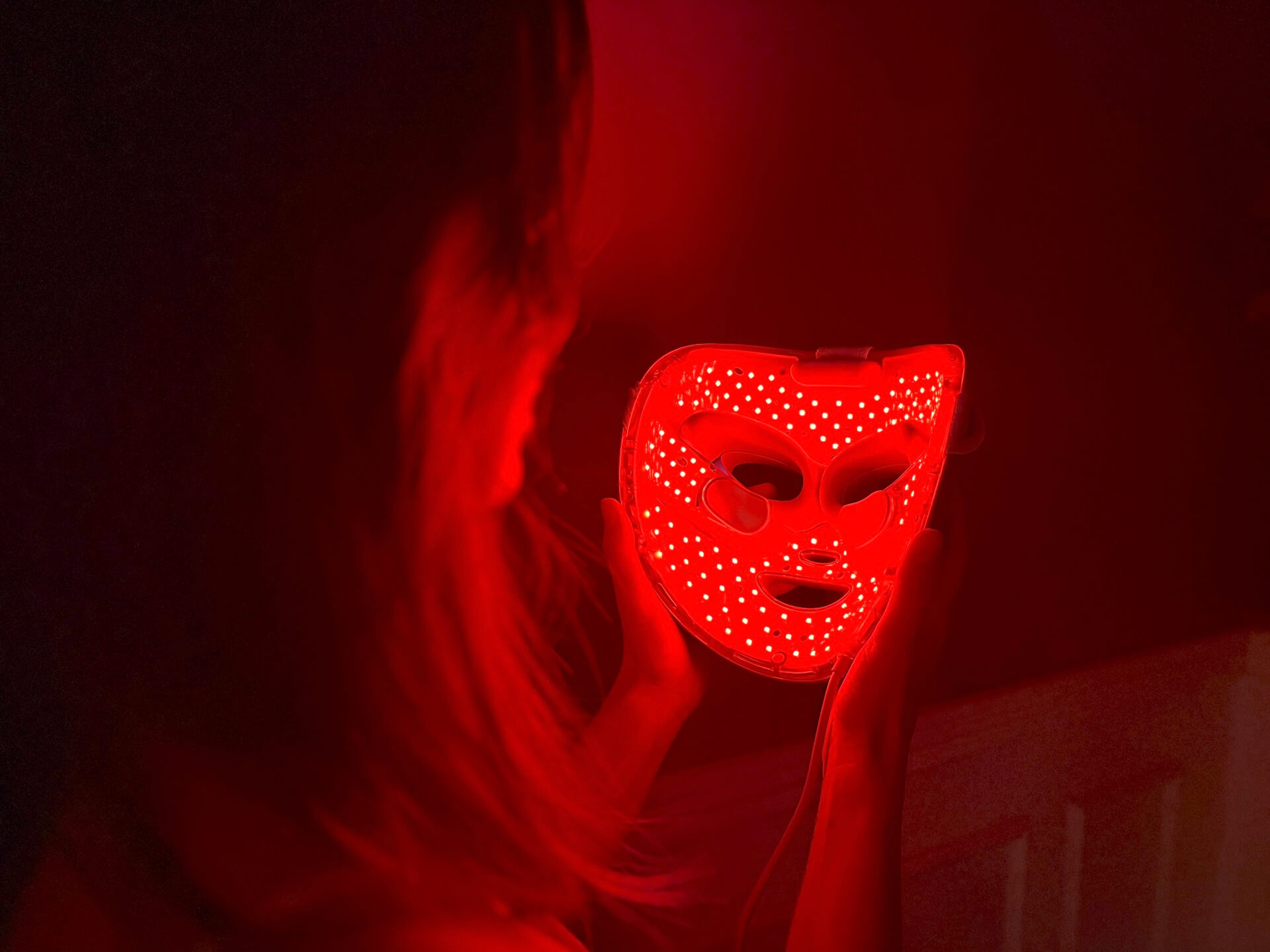 Kvinde der kigger ind i Shark CryoGlow LED Face Mask