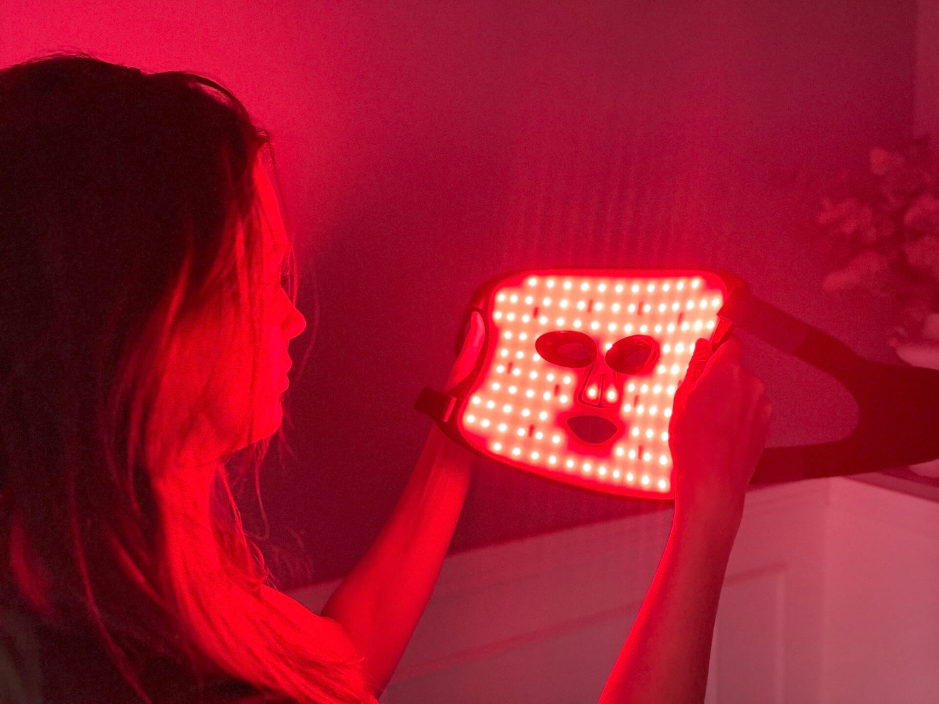 Kvinde der kigger på tændt Comforth Light Pro led maske