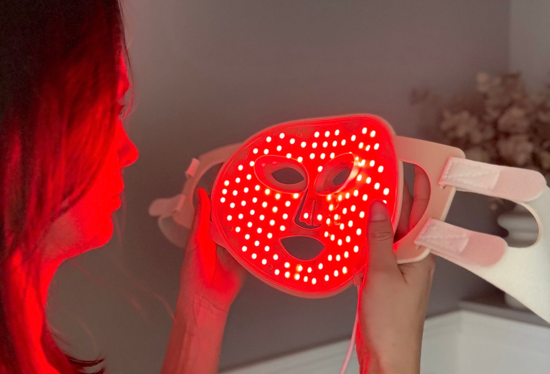 Kvinde der kigger på tændt Scandiface Skinboosting LED mask