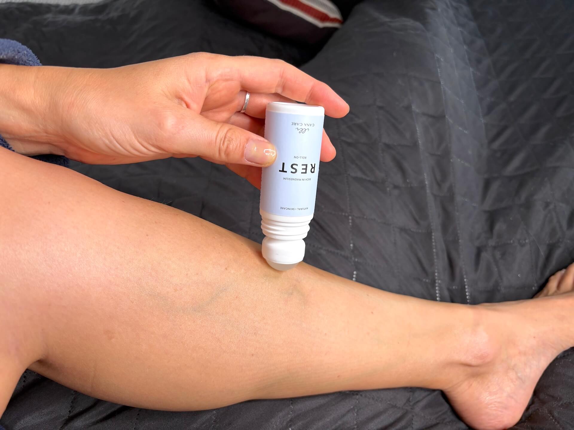 Kvinde der ruller Cana Care REST roll-on på ben