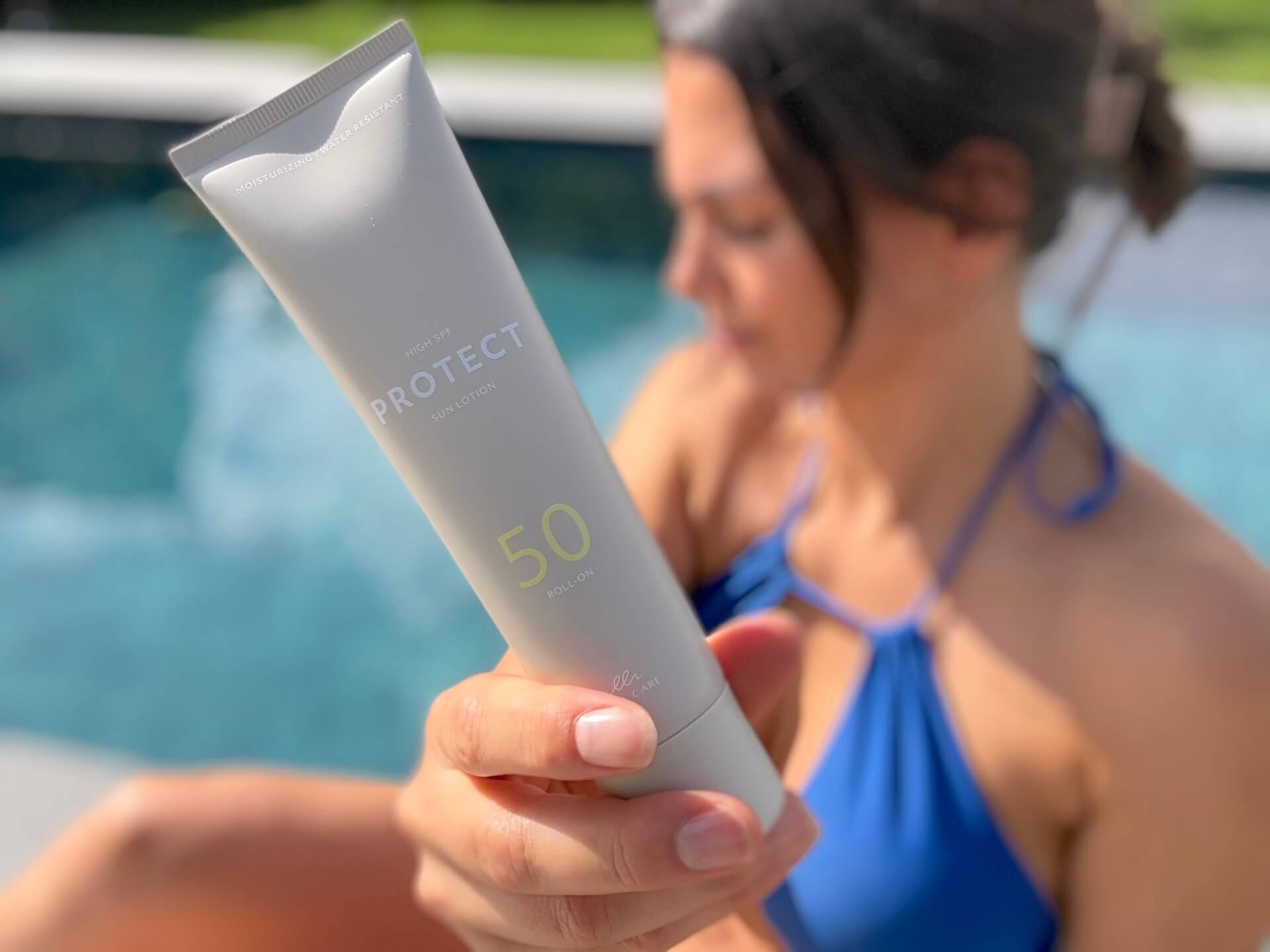 Kvinde der sidder med Cana Care PROTECT Sun Lotion SPF 50 roll-on