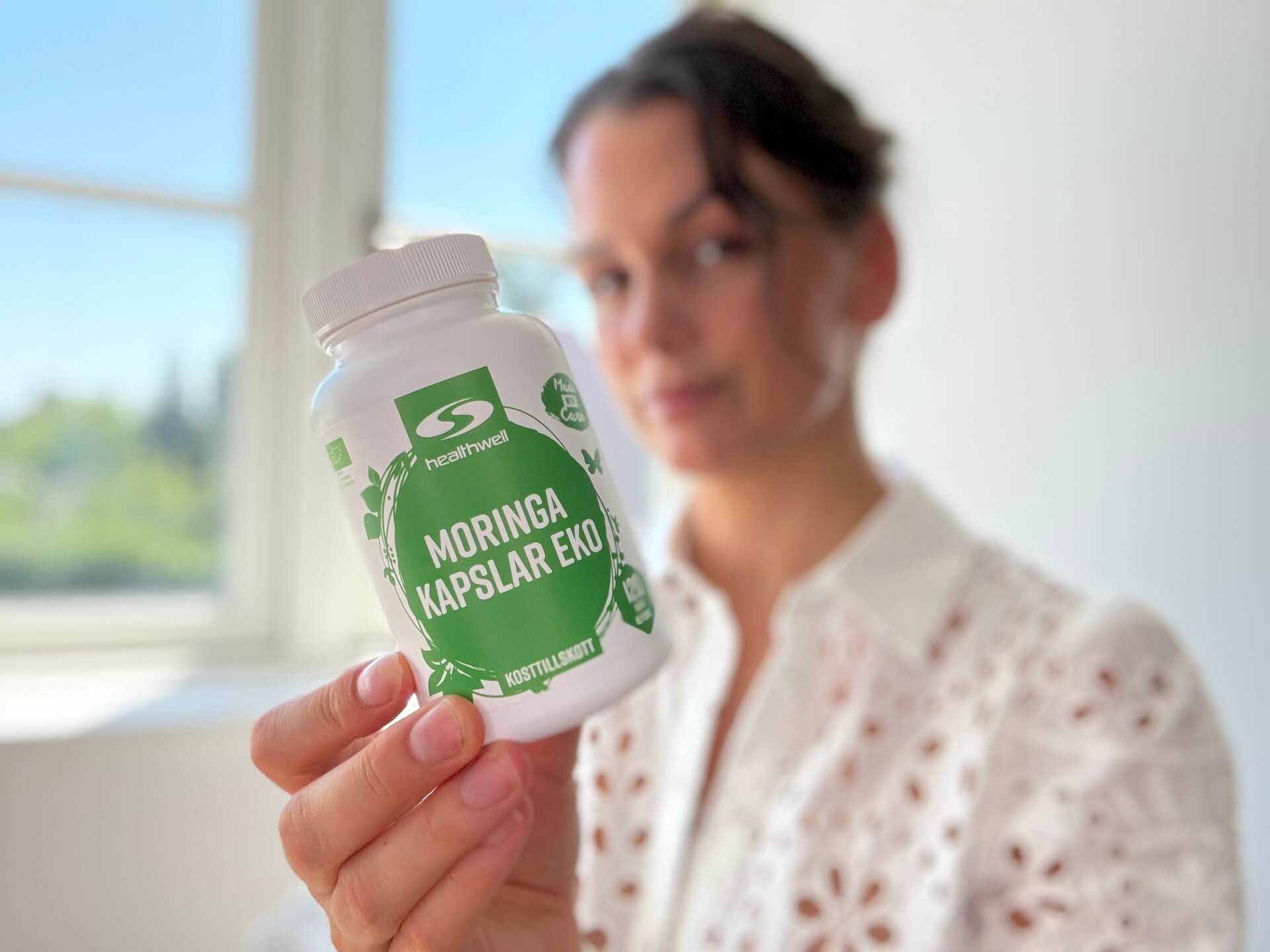 Kvinde der sidder med Healthwell Moringa Kapsler ØKO