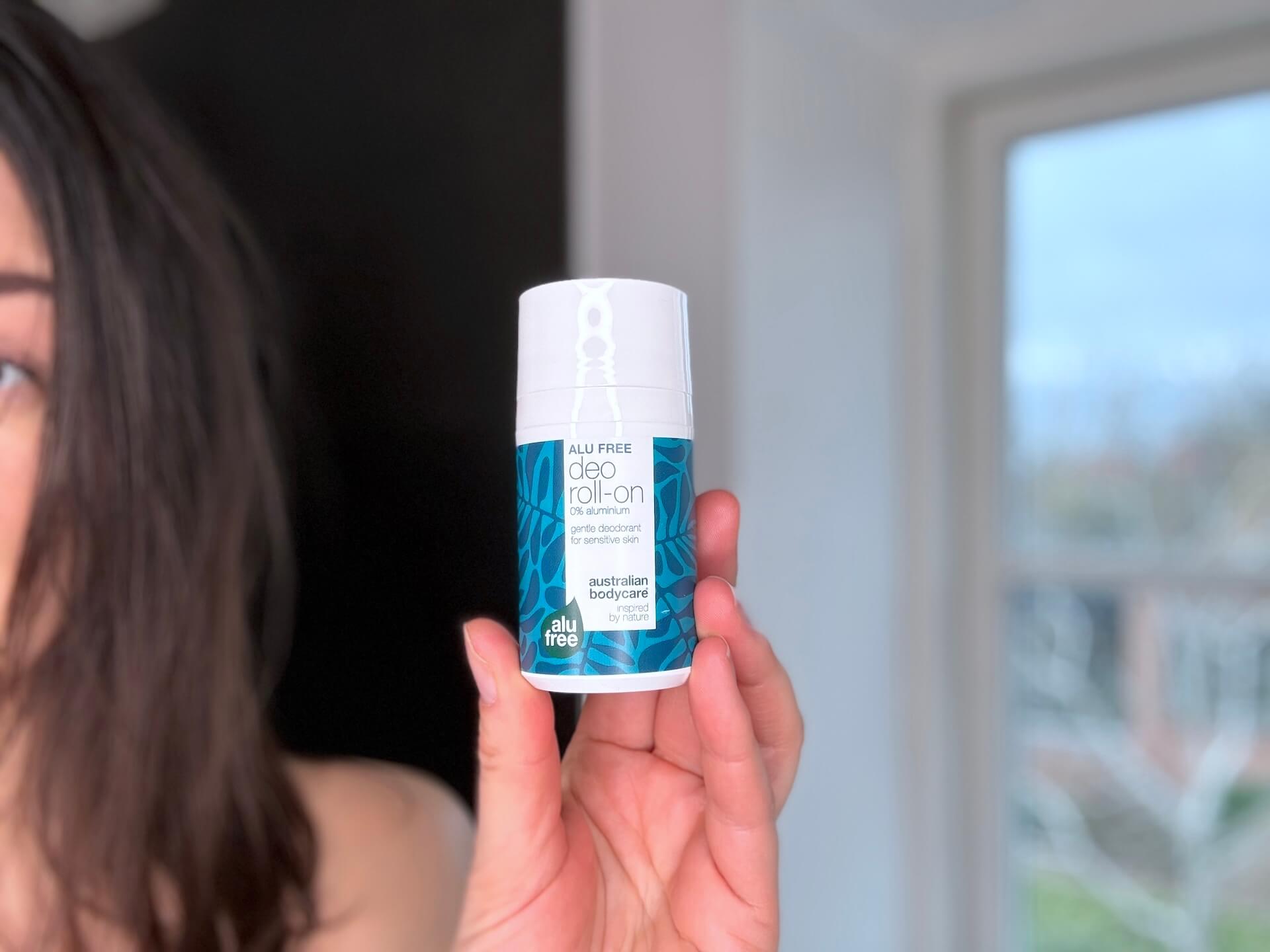 Kvinde der står med Australian Bodycare Alu Free Deo Roll-On