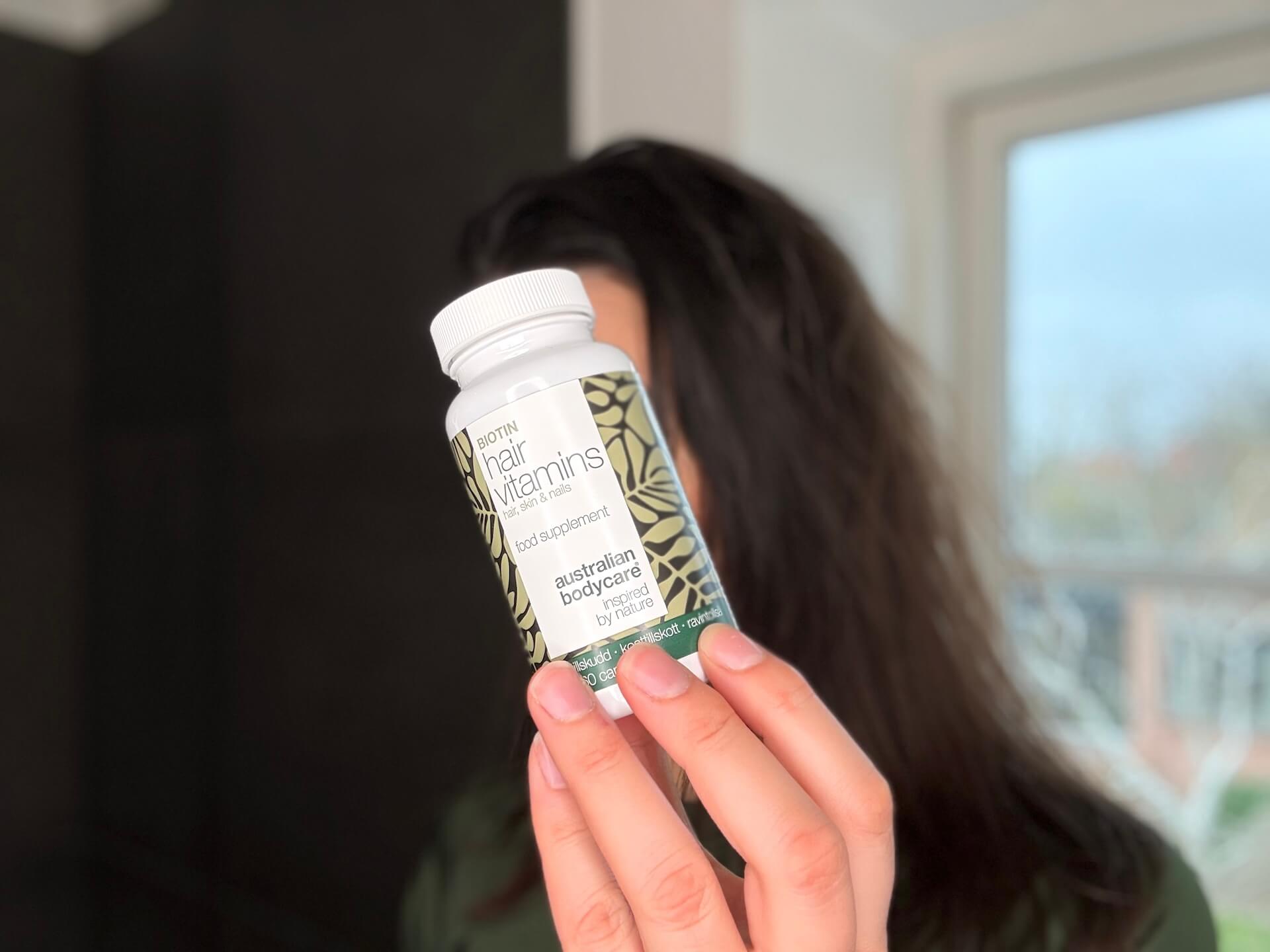 Kvinde der står med Australian Bodycare Hair Vitamins