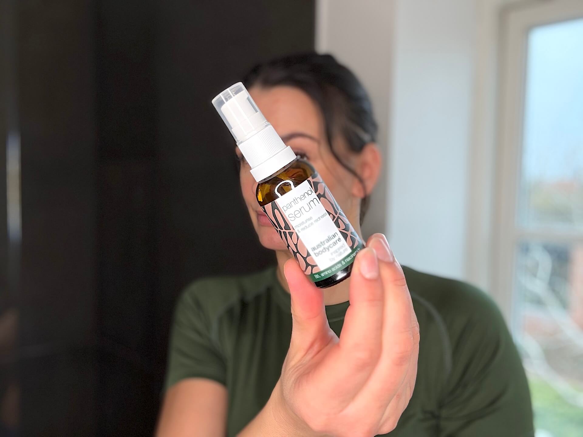 Kvinde der står med Australian Bodycare Panthenol Serum