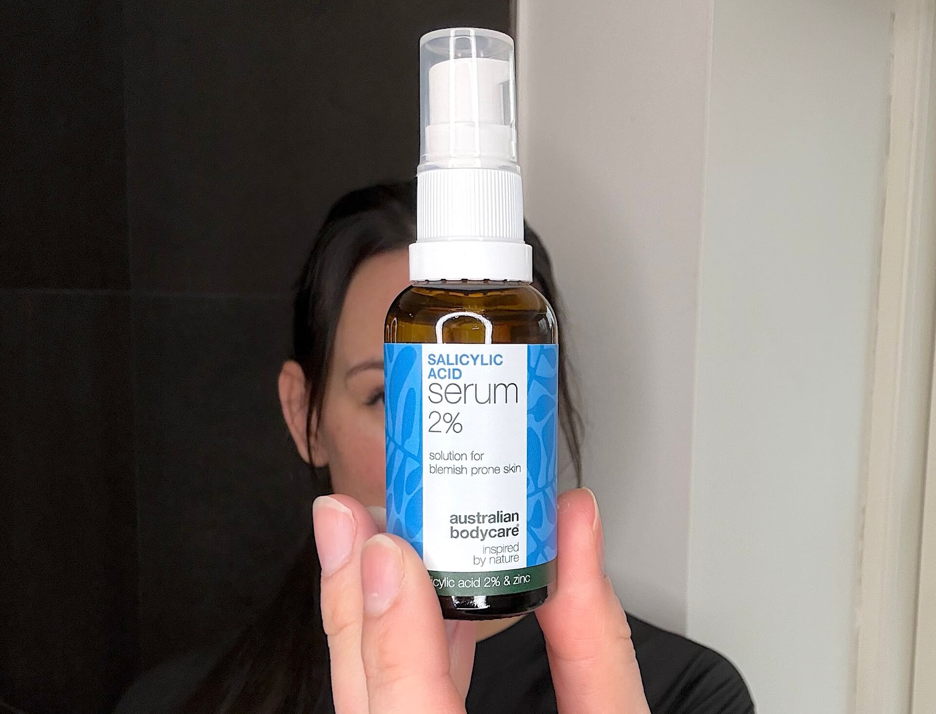 Kvinde der står med Australian Bodycare Salicylic Acid Serum 2%
