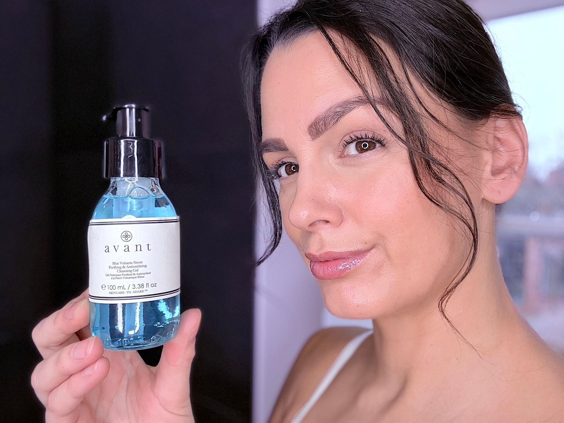 Kvinde der står med Avant Skincare Blue Volcanic Stone Purifying & Antioxidising Cleansing Gel