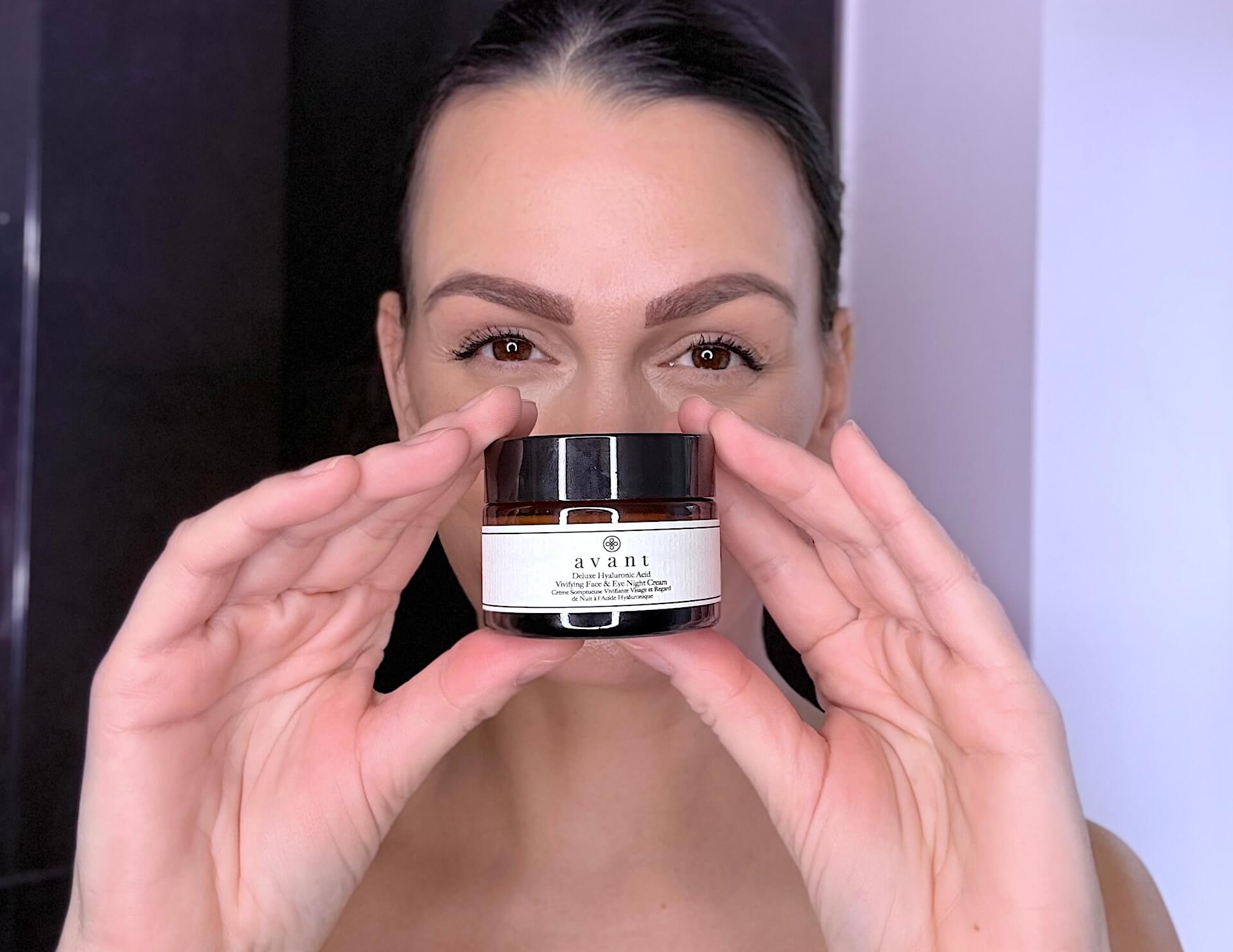 Kvinde der står med Avant Skincare Deluxe Hyaluronic Acid Vivifying Face & Eye Night Cream
