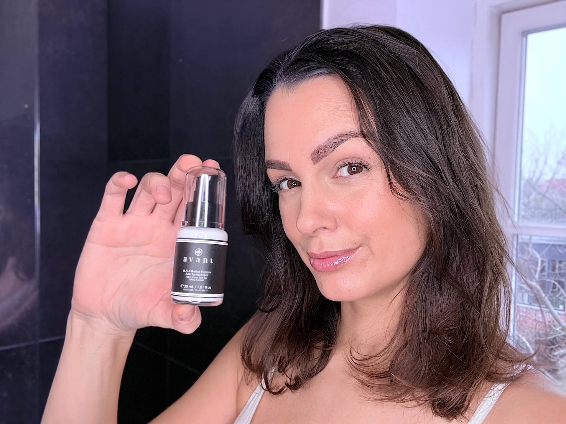 Kvinde der står med Avant Skincare R.N.A Radical Firmness Anti-Ageing Serum