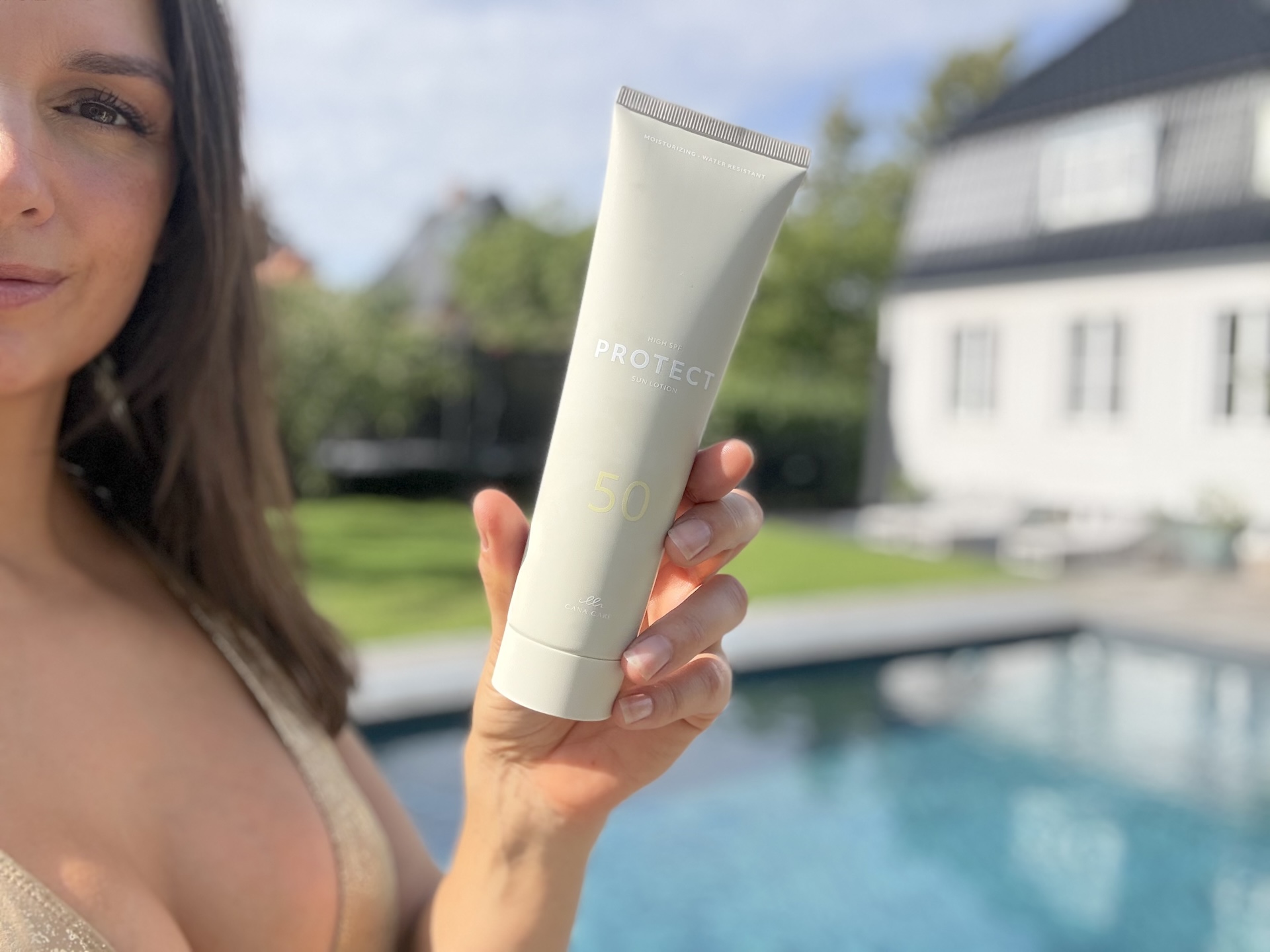 Kvinde der står med Cana Care PROTECT Sun Lotion SPF50