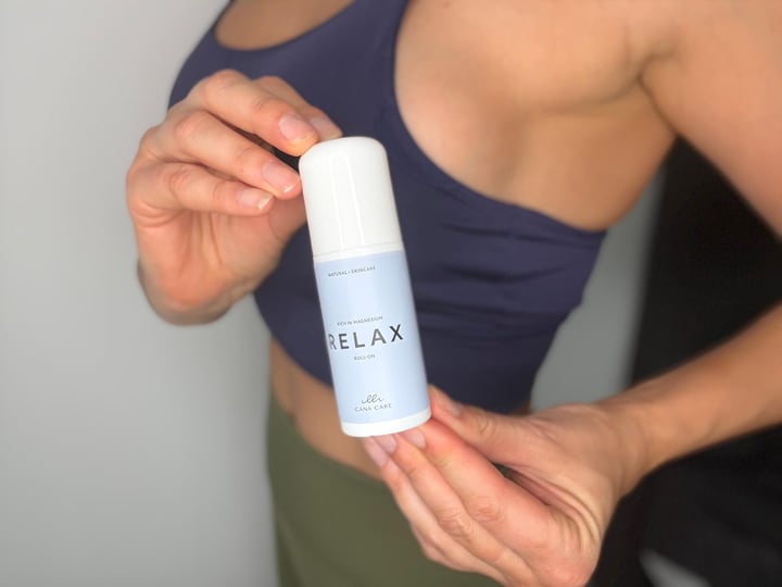 Kvinde der står med Cana Care RELAX roll-on