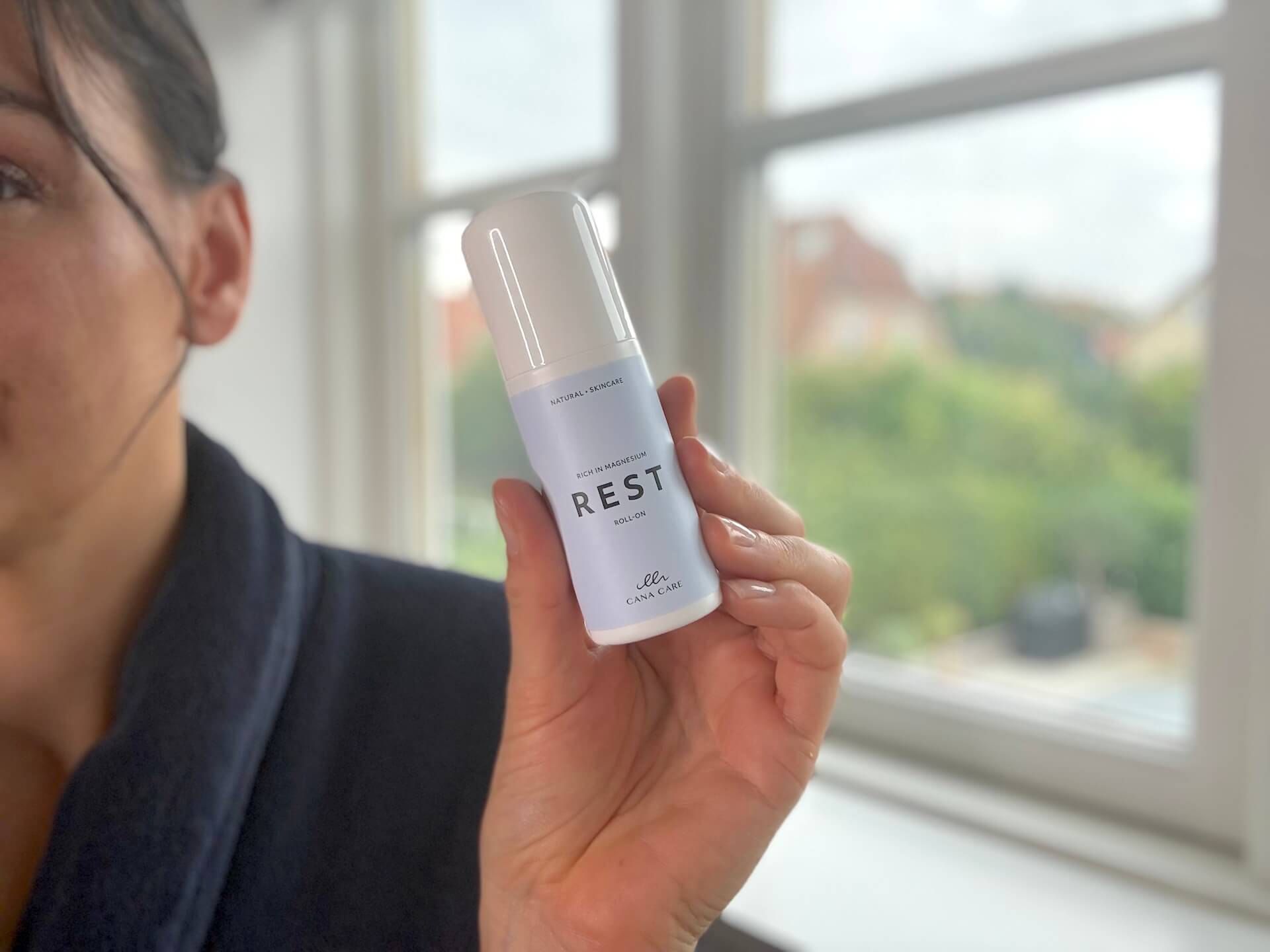 Kvinde der står med Cana Care REST roll-on