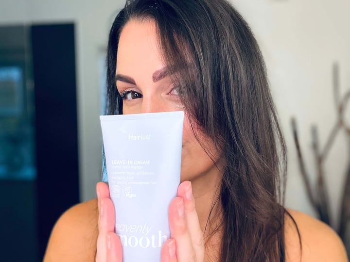 Kvinde der står med glattecreme fra Hairlust