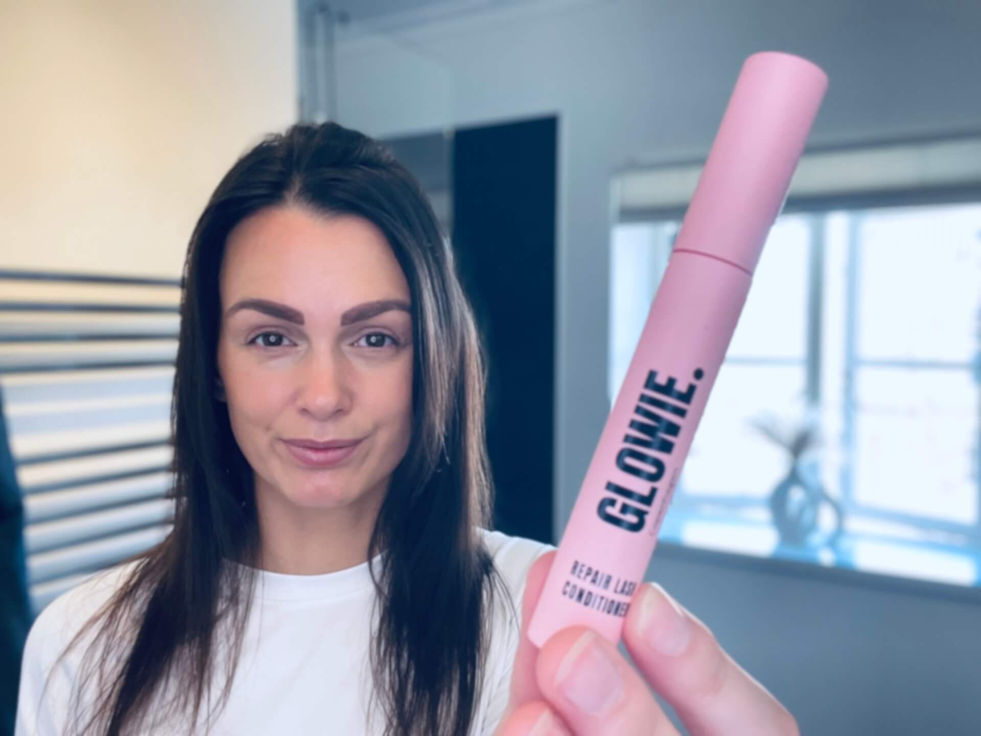 Kvinde der står med Glowie Eyelash Conditioner