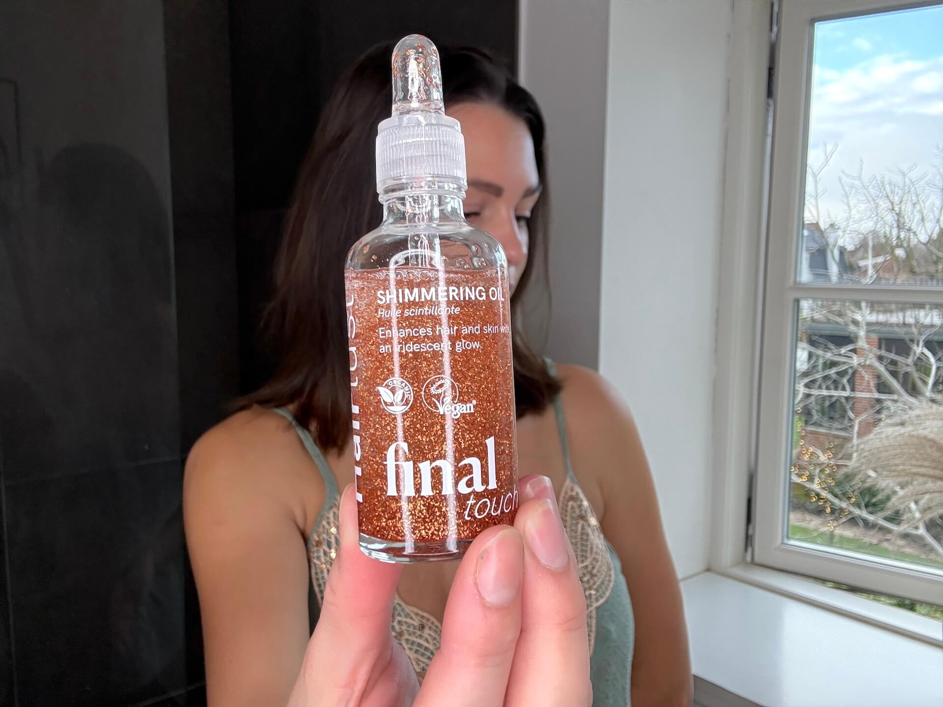 Kvinde der står med Hairlust Final Touch Shimmering Oil