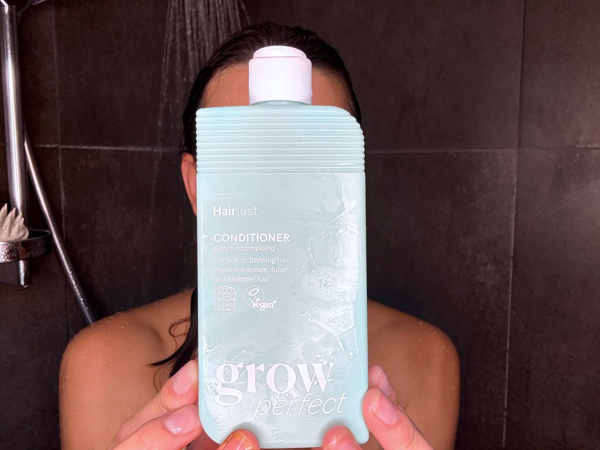 Kvinde der står med Hairlust Grow Perfect Conditioner