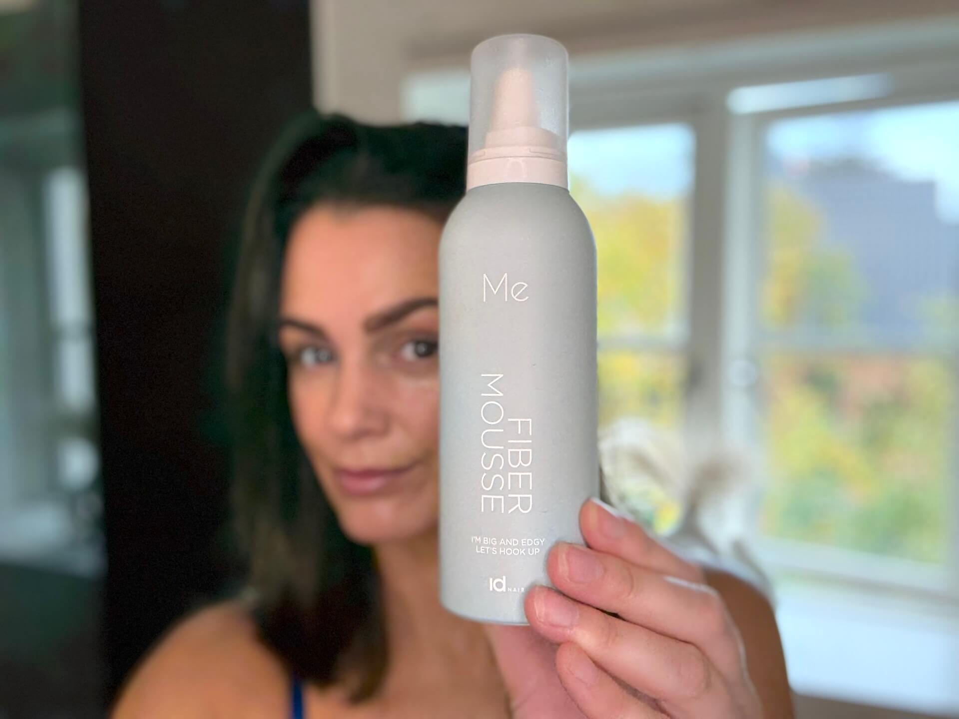 Kvinde der står med IdHAIR Me Fiber Mousse