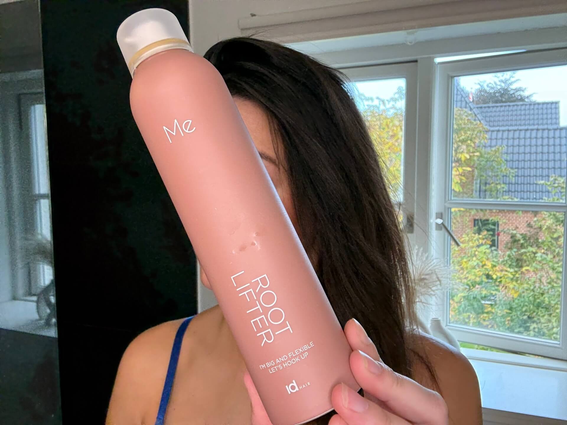Kvinde der står med IdHAIR Me Root Lifter