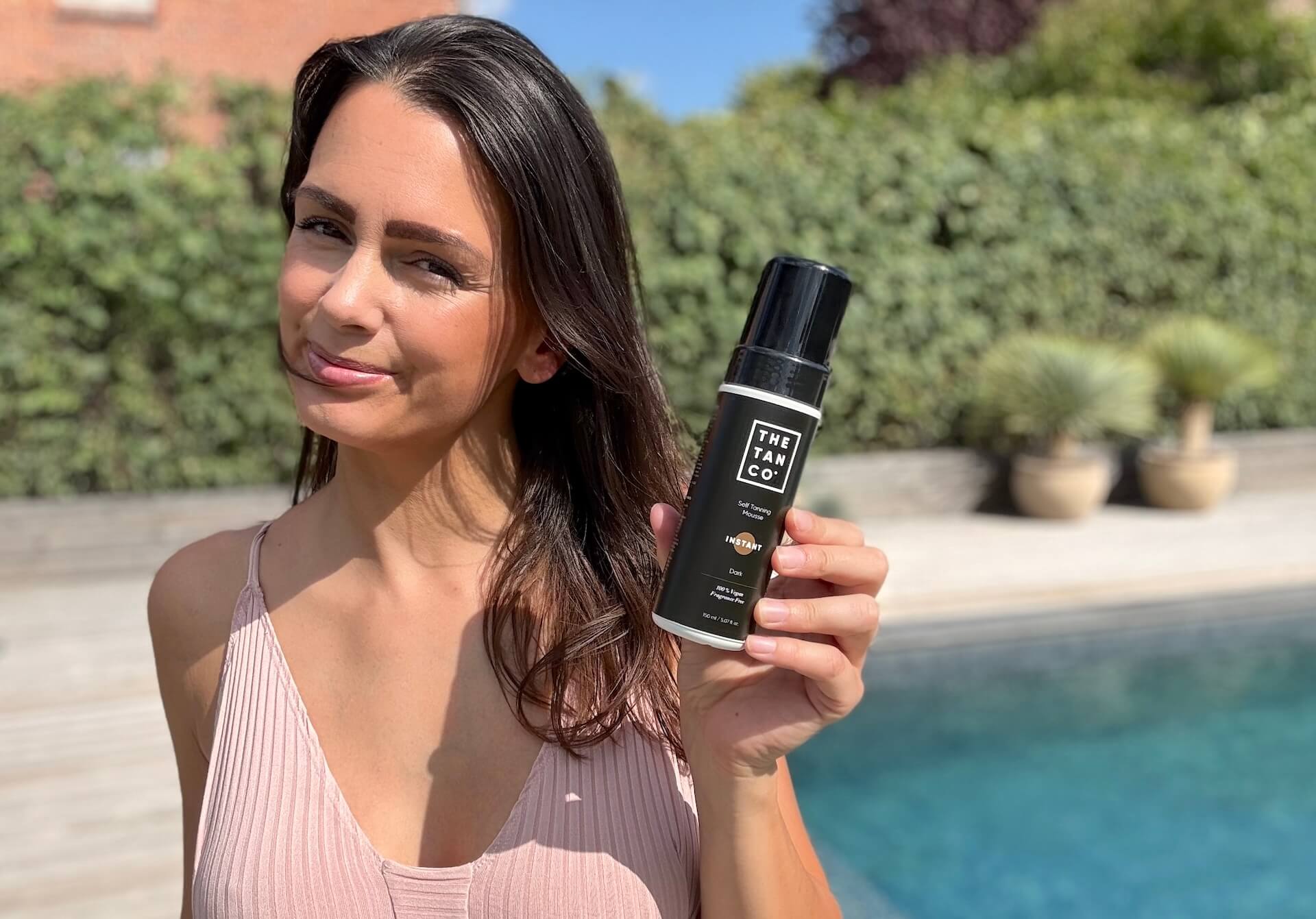 Kvinde der står med The Tan Co Instant Dark Selvbruner Mousse