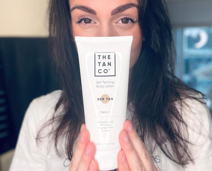 Kvinde der står med The Tan Co selvbruner lotion
