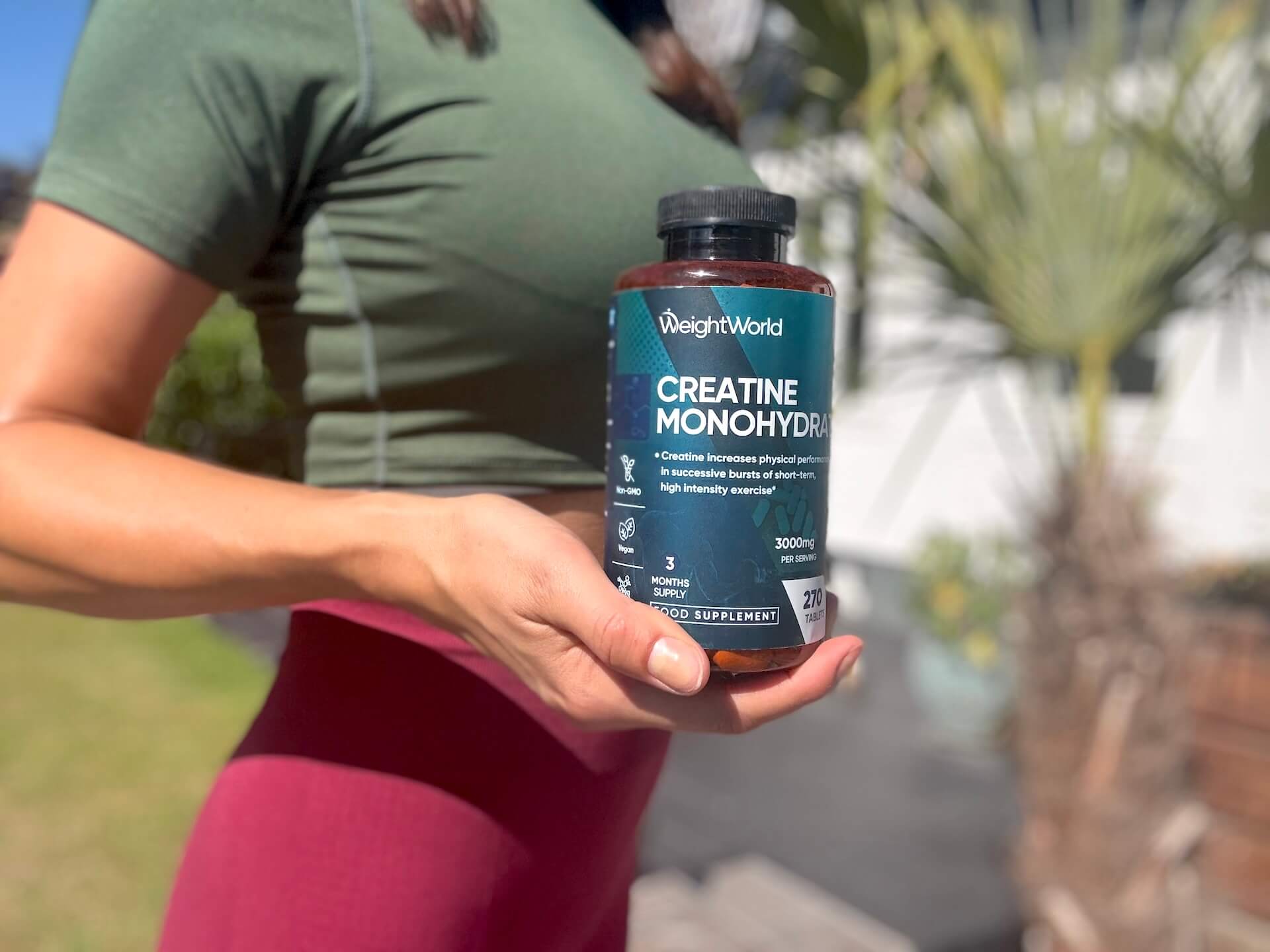 Kvinde der står med Weightworld Creatine Monohydrate tabletter