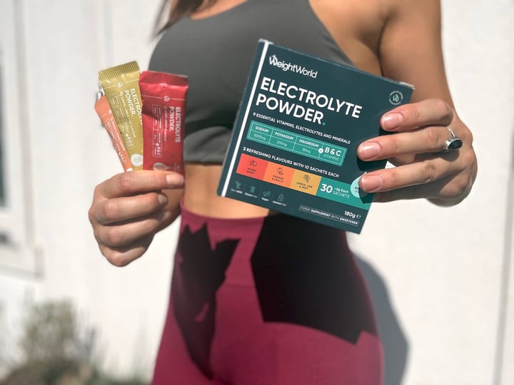 Kvinde der står med Weightworld Electrolyte Powder