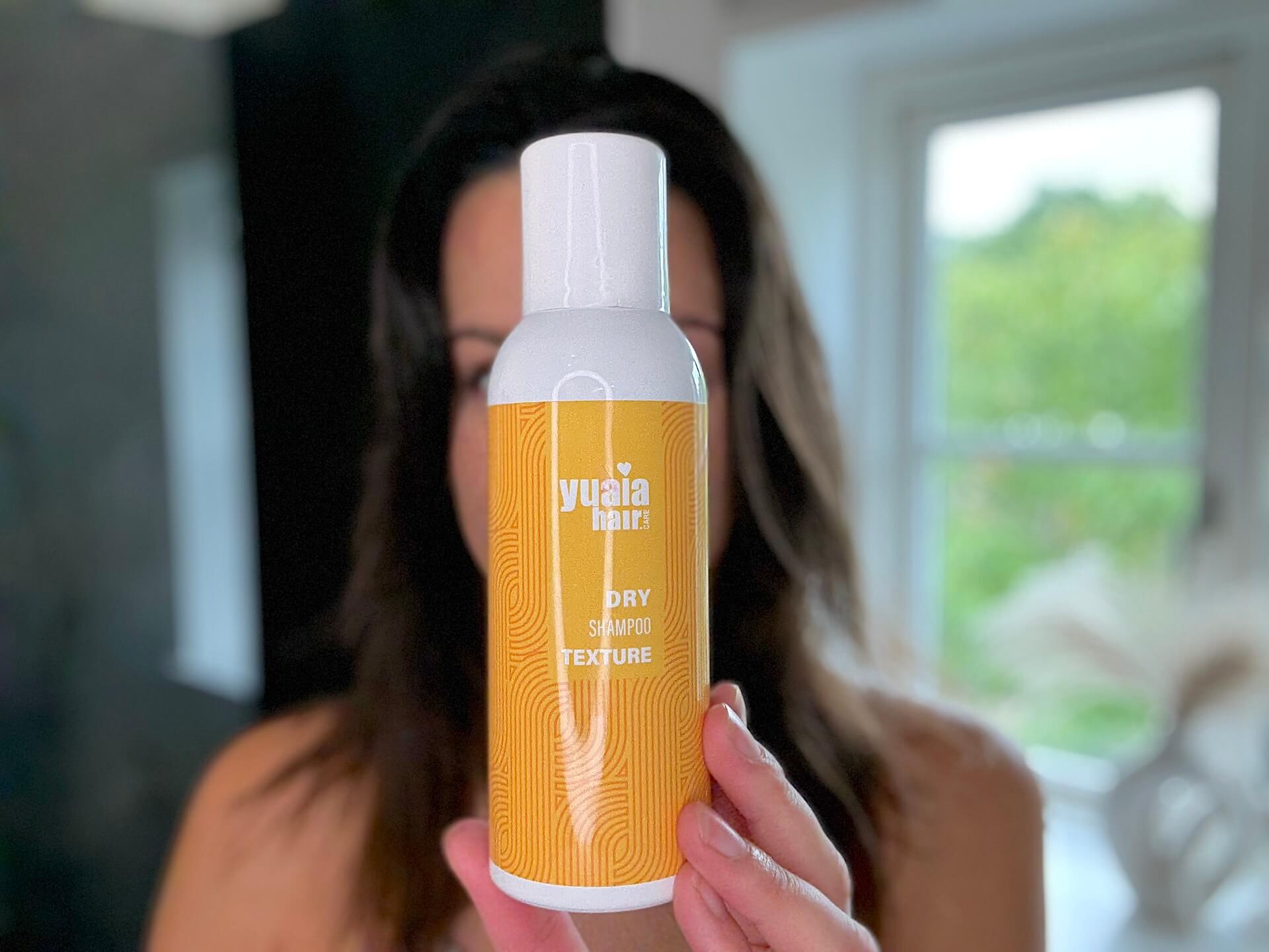 Kvinde der står med Yuaia Haircare Dry Shampoo Texture