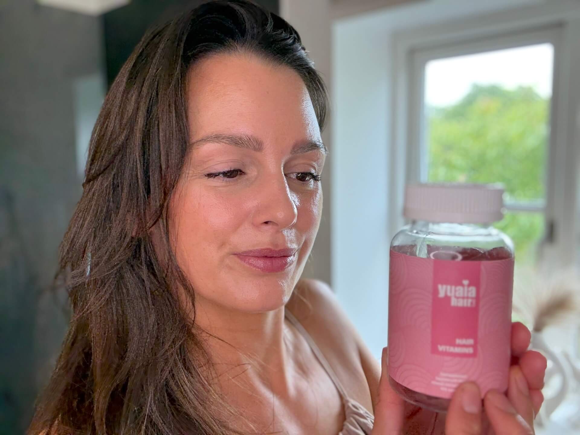 Kvinde der står med Yuaia Haircare Hair Vitamins