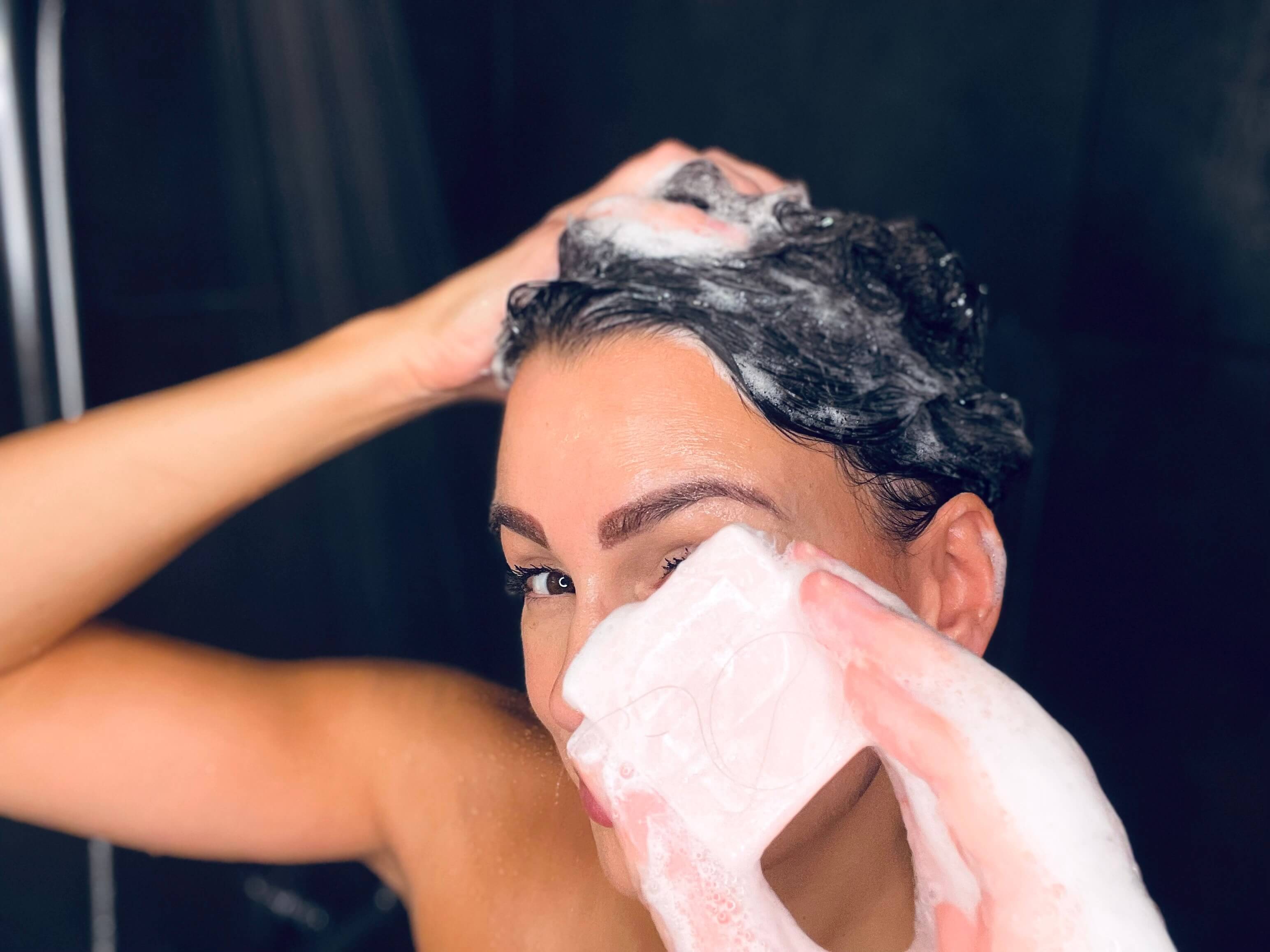 Kvinde der vasker hår med Hairlust Strengthening shampoo bar