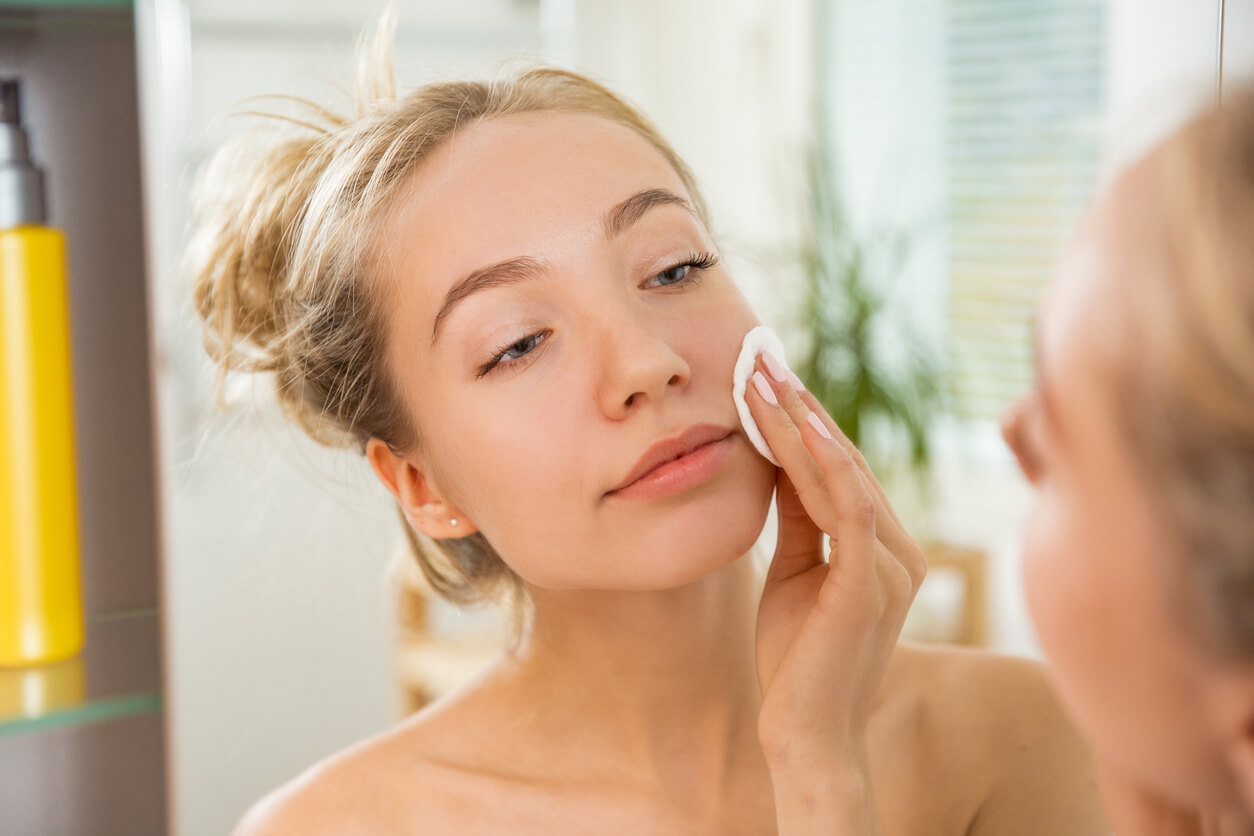 Kvinde fjerner makeup fra ansigtet med vatrondel
