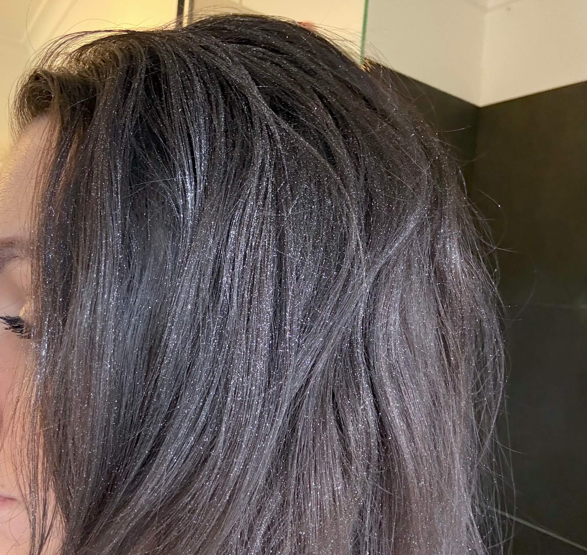 Kvinde fra siden med glimmer fra Hairlust Final Touch Silver Glitter Spray