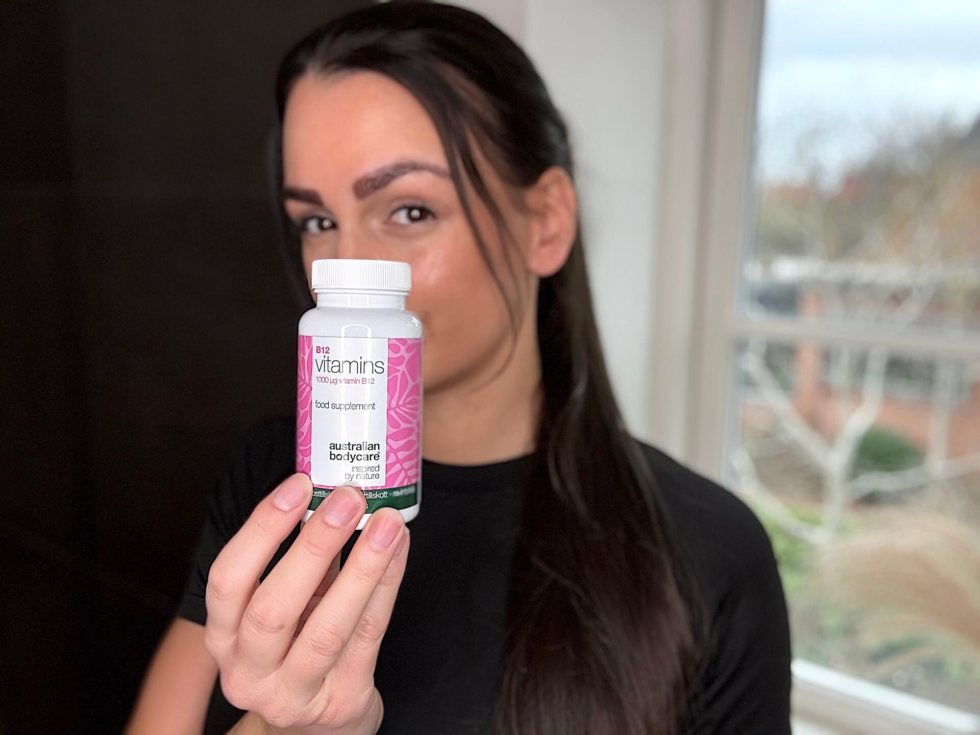 Kvinde med Australian Bodycare B12 Vitamins foran sig