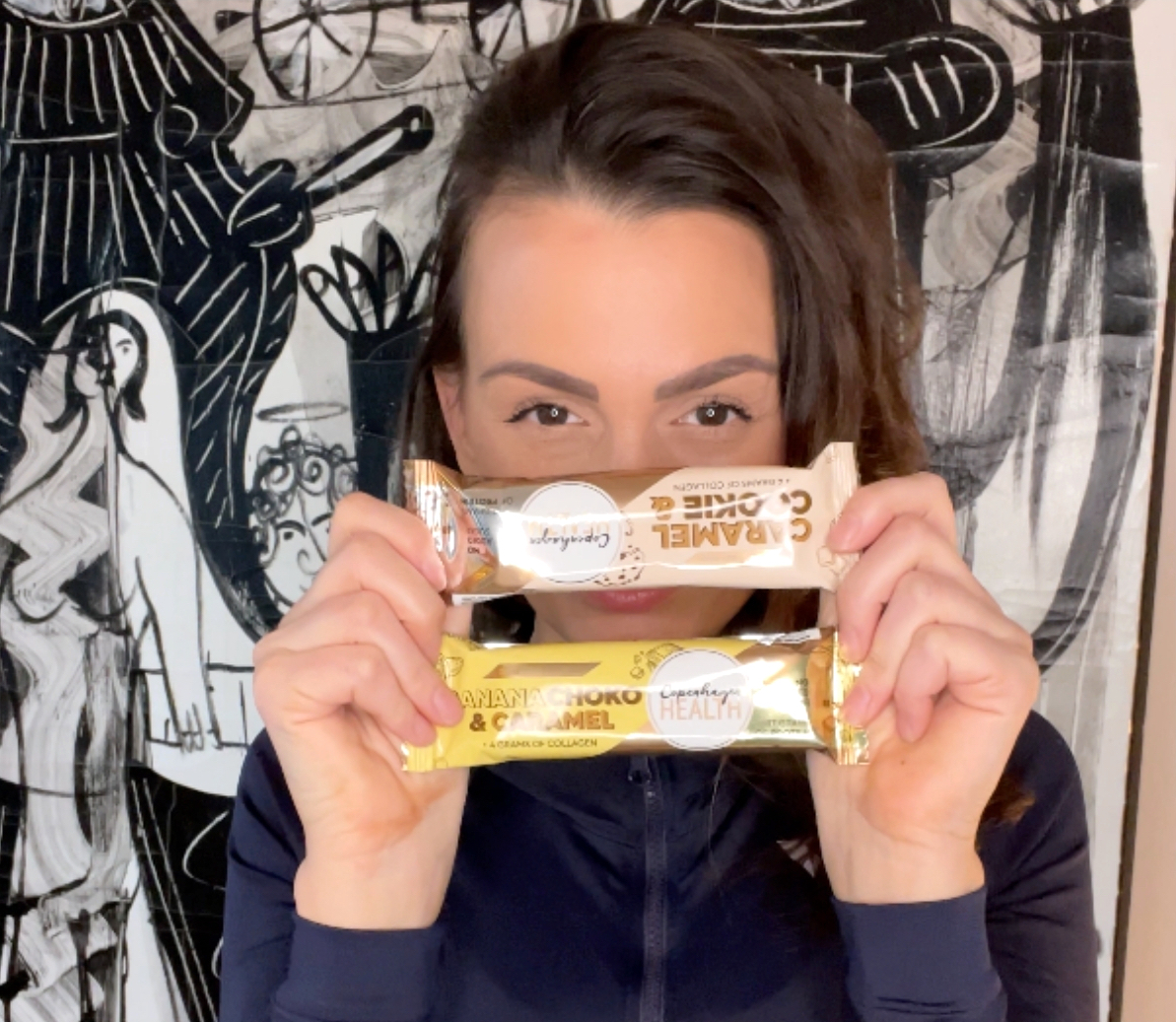 Kvinde med Copenhagen Health Proteinbarer foran sig