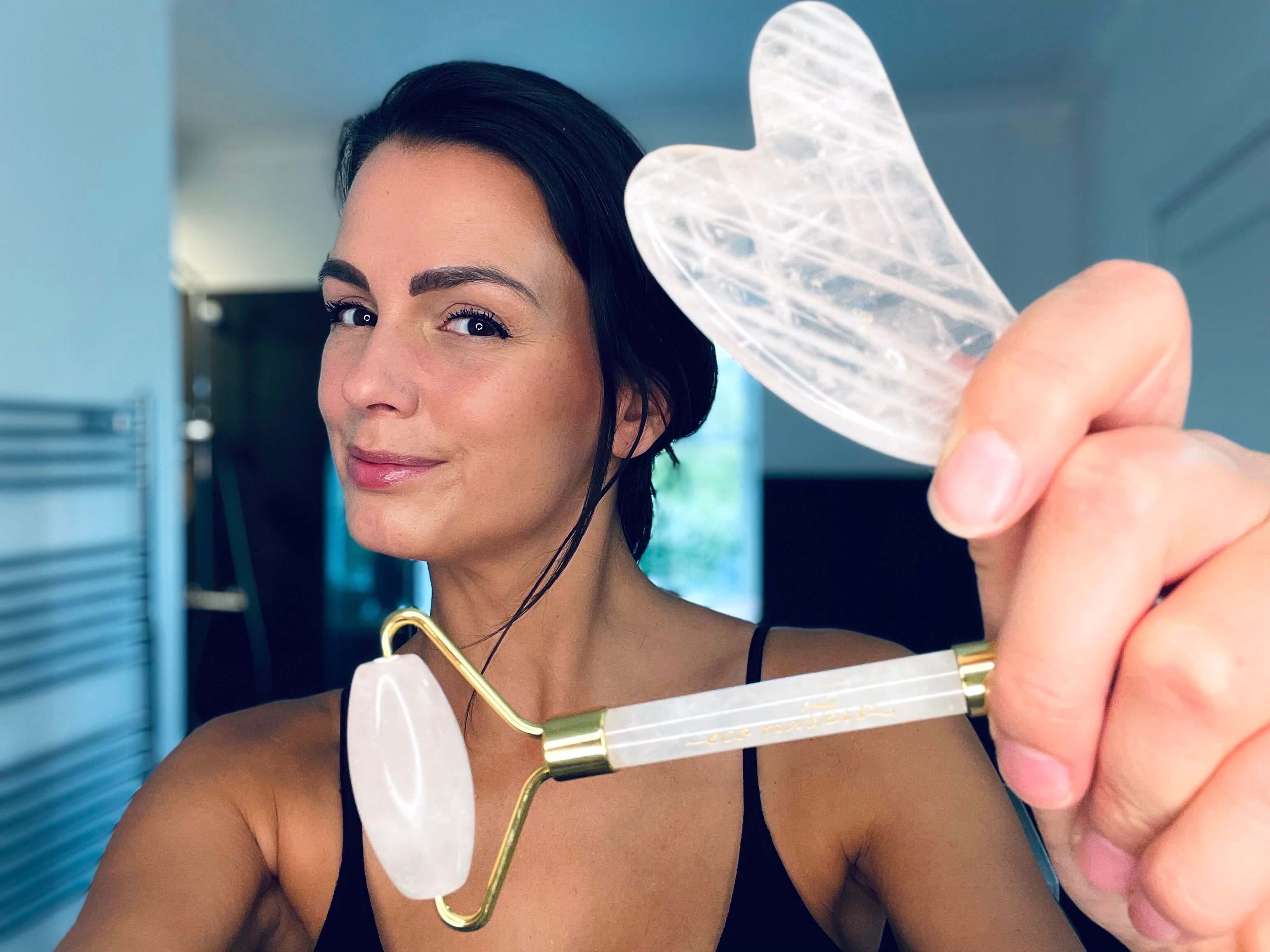 Kvinde med Eco Masters rose quartz gua sha sten & faceroller