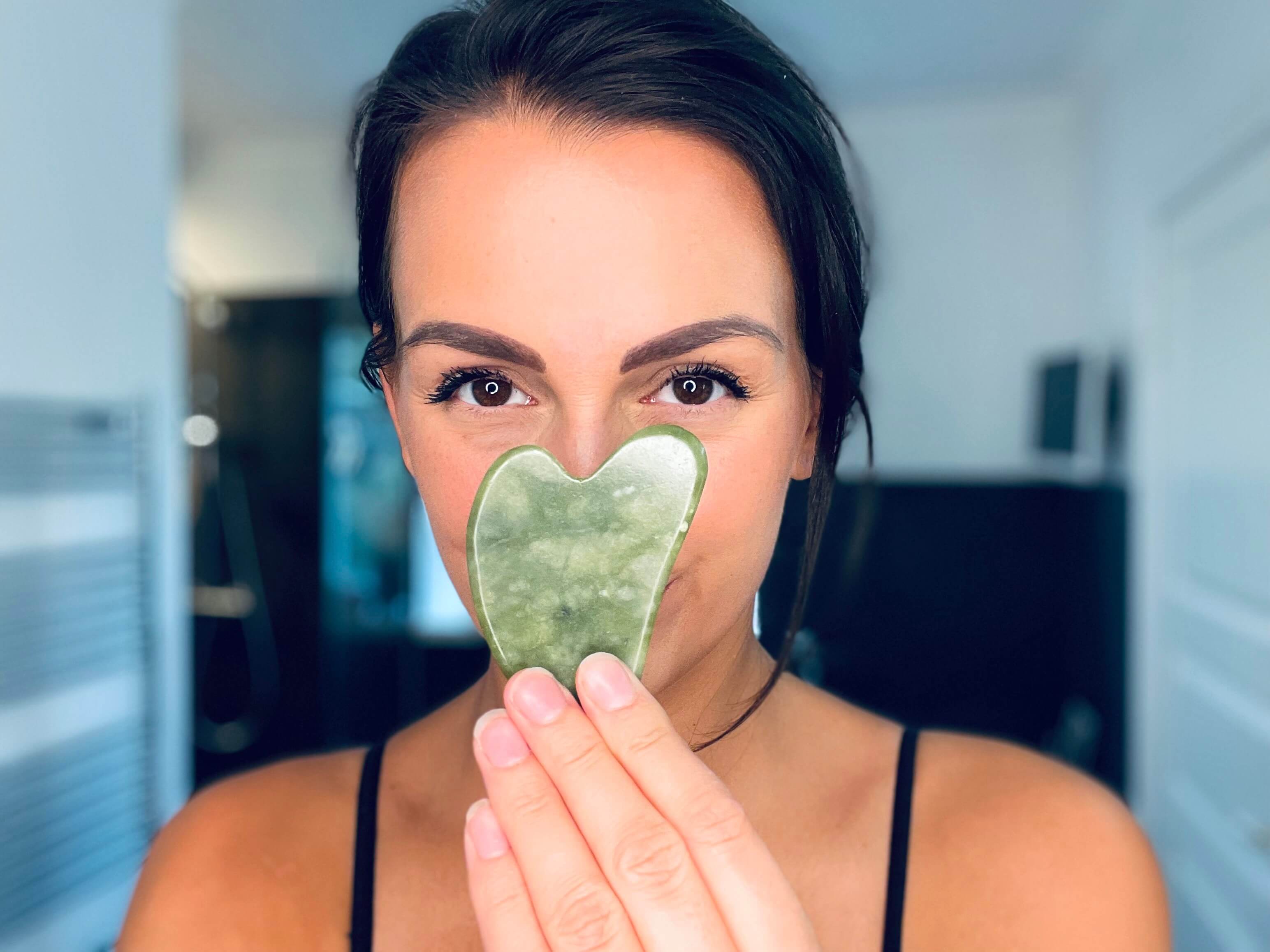 Kvinde med grøn gua sha sten