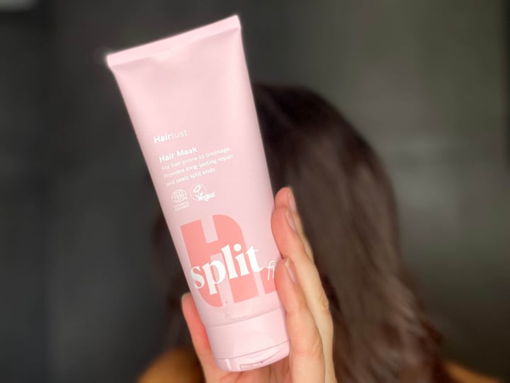 Kvinde med Hairlust Split Fix hair mask i hånd