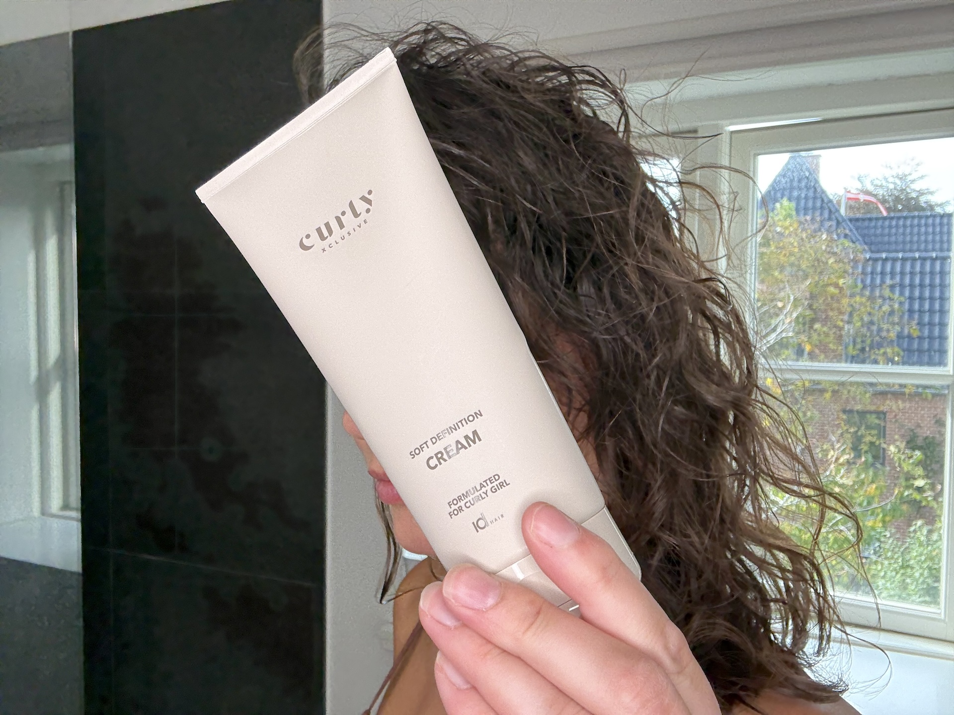 Kvinde med IdHAIR Curly Xclusive Soft Definition Cream