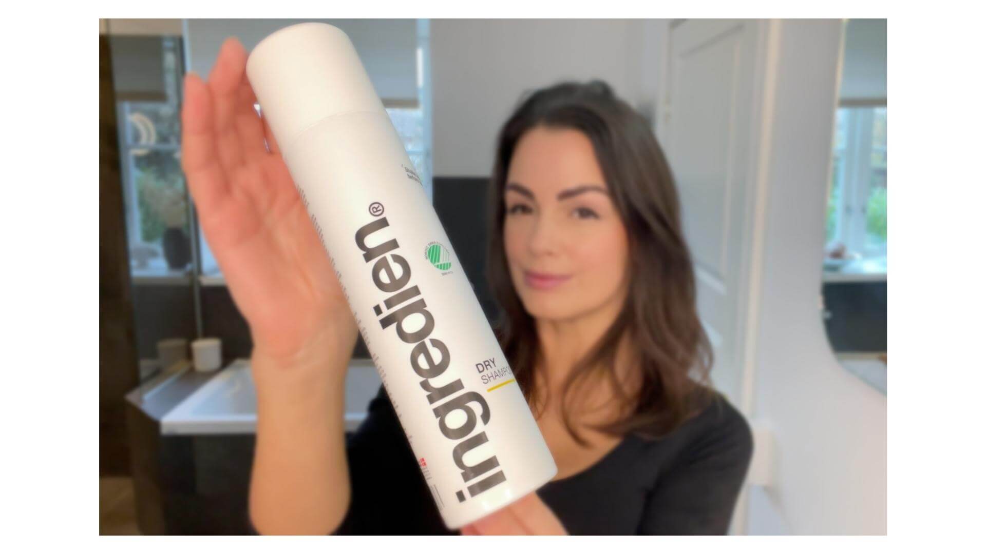 Kvinde med ingredien Dry Shampoo i hånden foran sig