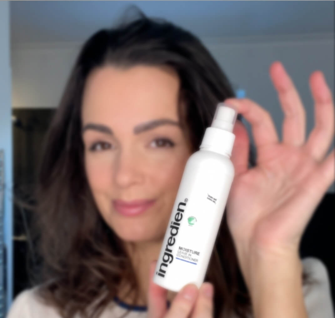 Kvinde med ingredien Moisture leave-in conditioner i hænderne