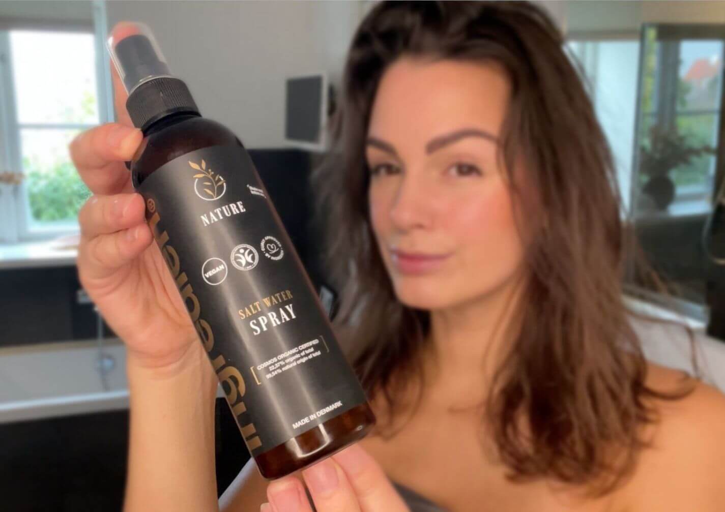 Kvinde med ingredien Nature Salt Water Spray foran sig