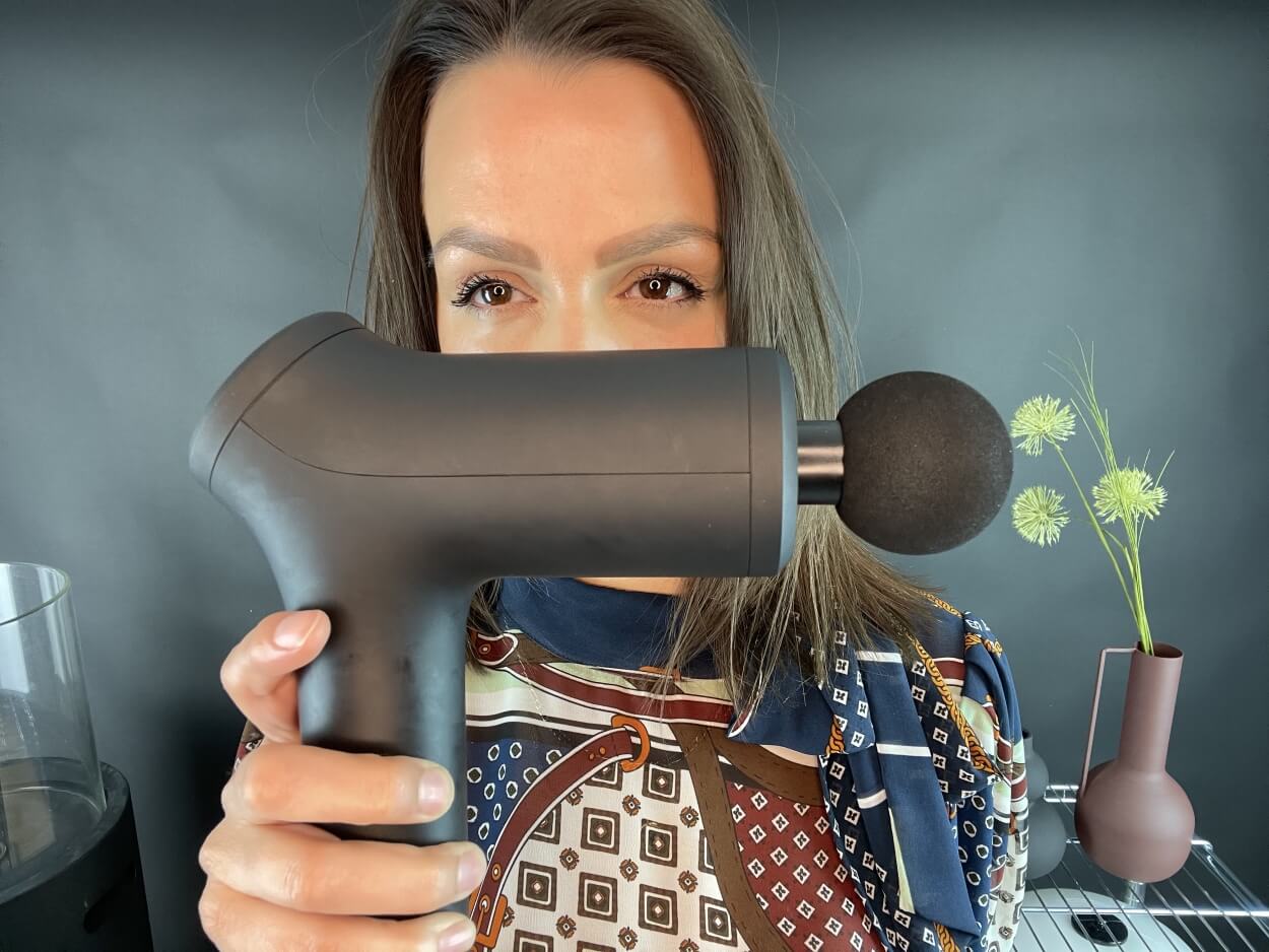 Kvinde med massagepistol klar til brug
