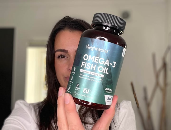 Kvinde med Omega-3 Fiskeolie 2000mg foran sig