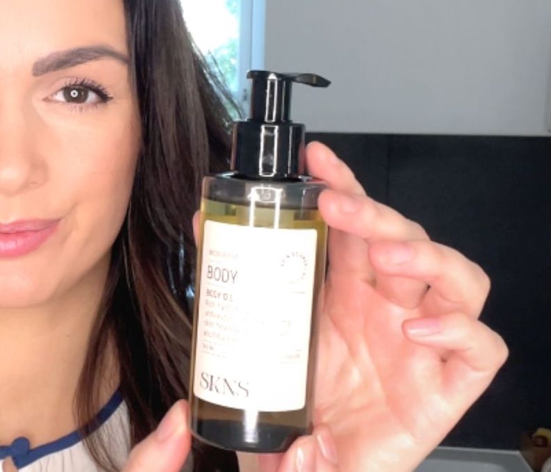 Kvinde med SKNS body oil i hånden