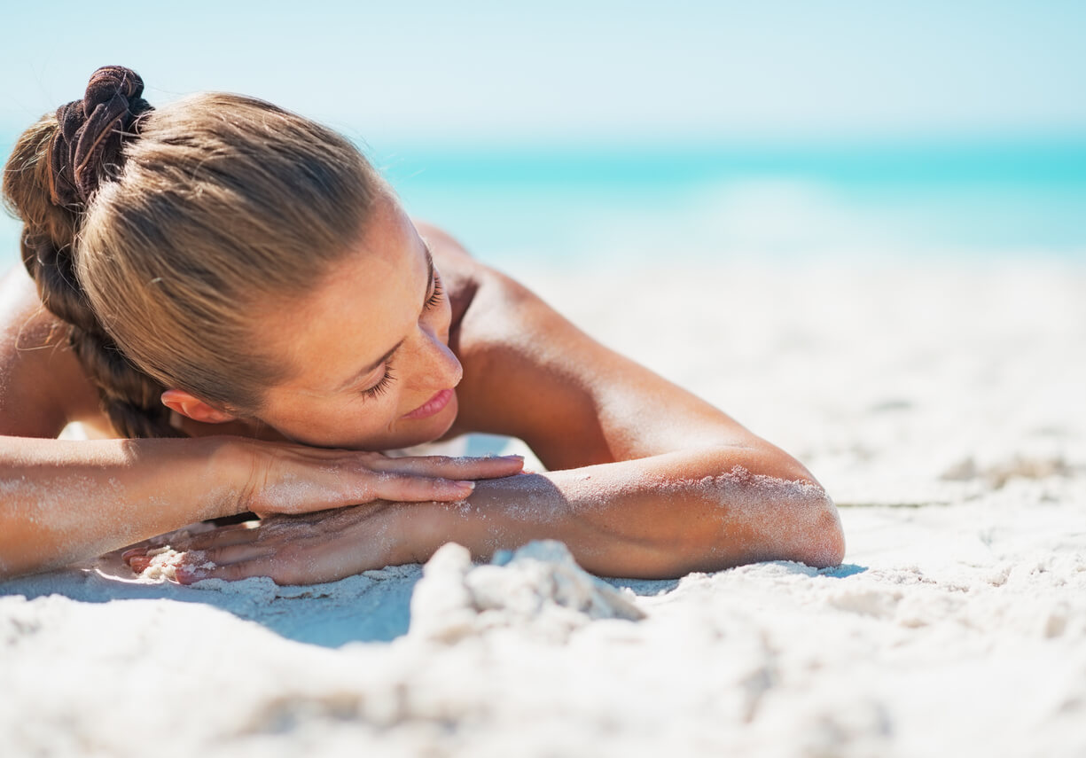 Kvinde solbader på strand